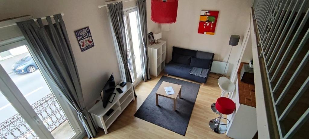 a small living room with a couch and a television at Apartment Bordeaux Bègles in Bègles