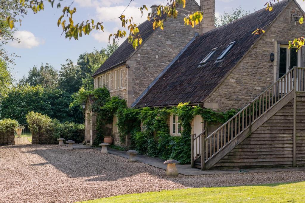 una vista exterior de una casa de piedra con escaleras en Great Ashley Farm Bed and Breakfast & Shepherds Huts en Bradford on Avon