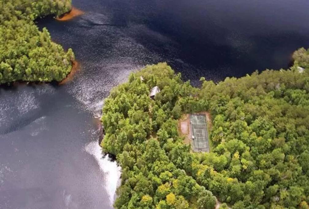 een luchtzicht op een rivier met bomen en een gebouw bij Spectacular Seven Keys Camp on Pristine Loon Lake 