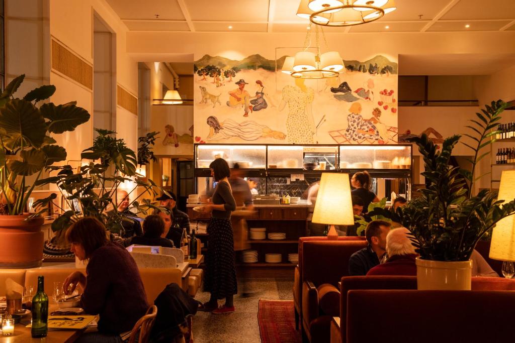 a group of people sitting at tables in a restaurant at Hotel Kinsley in Kingston