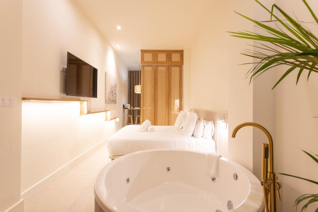 a bathroom with two beds and a bath tub at Reina Victoria Velázquez in Alicante