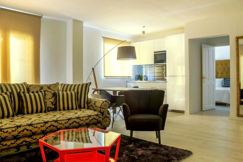 ein Wohnzimmer mit einem Sofa und einem Tisch in der Unterkunft Santa Cruz Apartments in Málaga