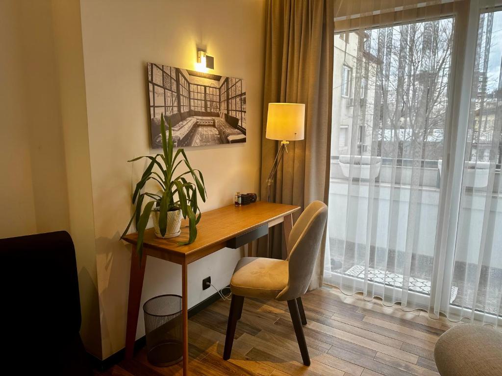 Habitación con ventana y escritorio con silla. en Stylish Downtown Apartment en Pristina