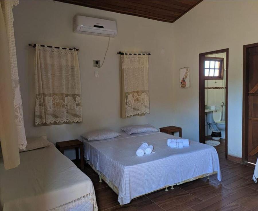 sypialnia z 2 łóżkami i oknem w obiekcie HOTEL FAZENDA CANARIO DA TERRA w mieście Rio Novo