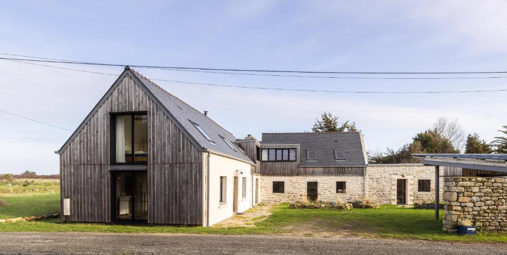 une maison de style grange avec un mur en pierre dans l'établissement Gîtes de Lézinadou - 14 personnes - Plomeur La Torche, à Plomeur