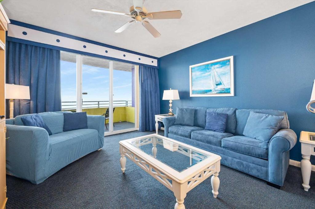 ein Wohnzimmer mit 2 blauen Sofas und einem Couchtisch in der Unterkunft Luxury 6th Floor 1 BR Condo Direct Oceanfront Wyndham Ocean Walk Resort Daytona Beach | 609 in Daytona Beach