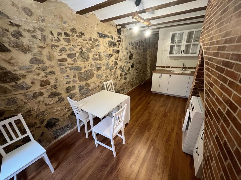 a kitchen with a table and chairs and a brick wall at Apartamento Rural Piedra in Jérica
