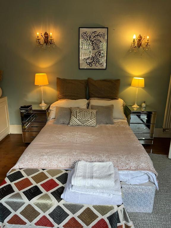 ein Schlafzimmer mit einem großen Bett mit zwei Nachttischen in der Unterkunft Dawn and Dudley the Sausage dog's Parkside Home in London