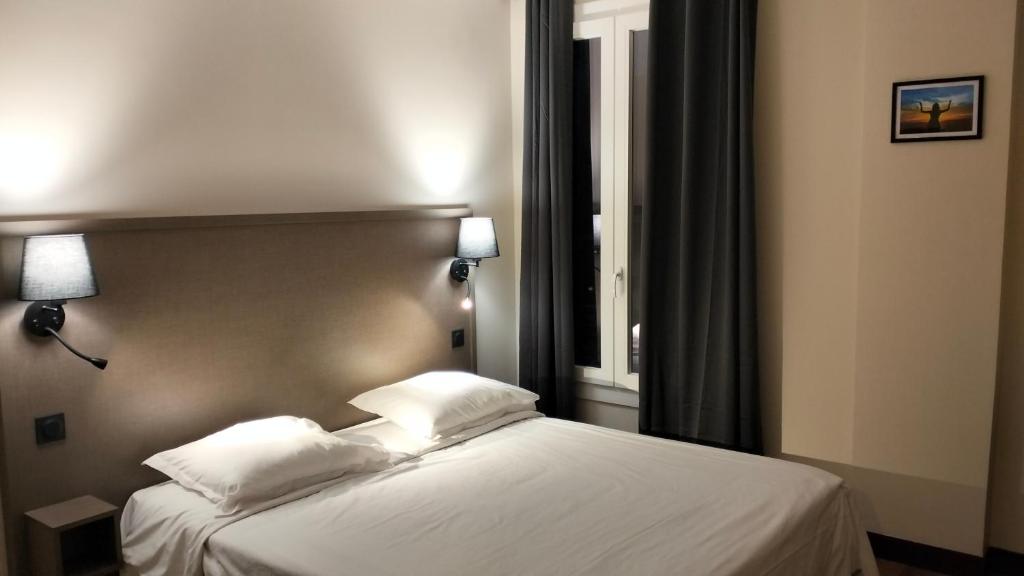 a bedroom with a bed with white sheets and pillows at HÔTEL ROYAL MONTREUIL in Montreuil