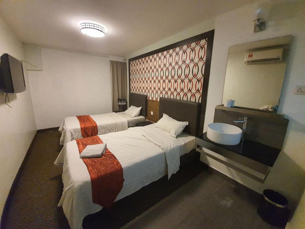 Postel nebo postele na pokoji v ubytování Warisan Hotel Kota Kinabalu
