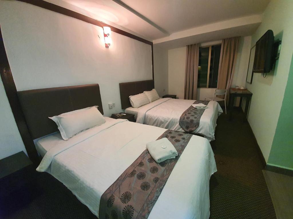 Postel nebo postele na pokoji v ubytování Warisan Hotel Kota Kinabalu