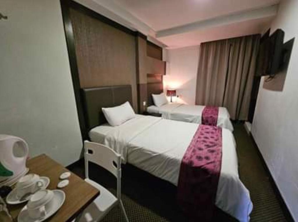 Postel nebo postele na pokoji v ubytování Warisan Hotel Kota Kinabalu
