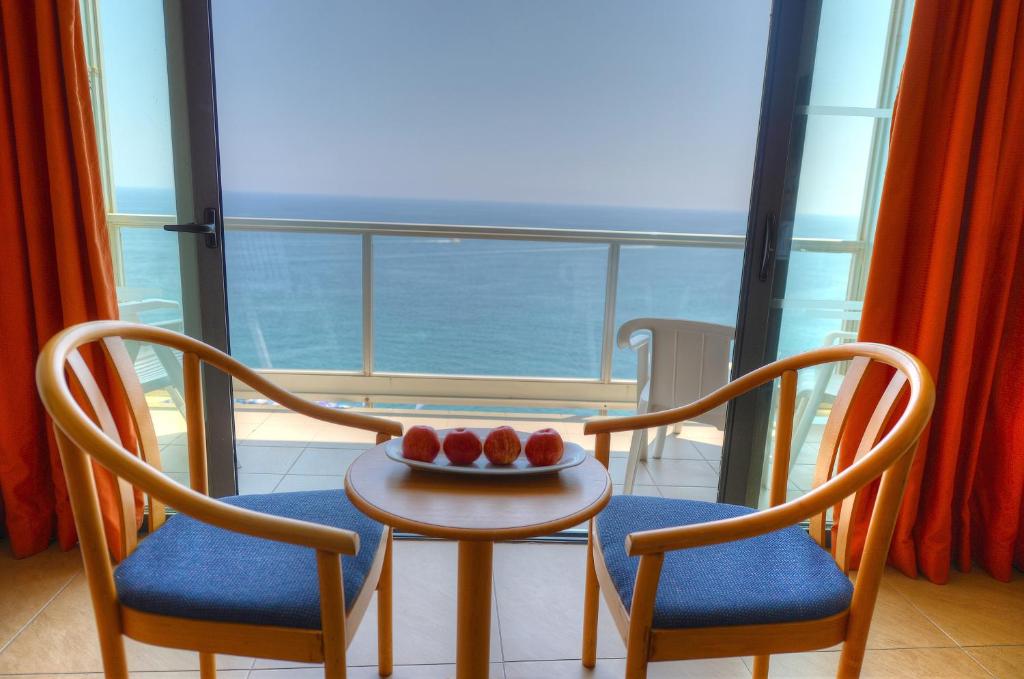a room with two chairs and a table with fruit on it at The Preluna Hotel in Sliema