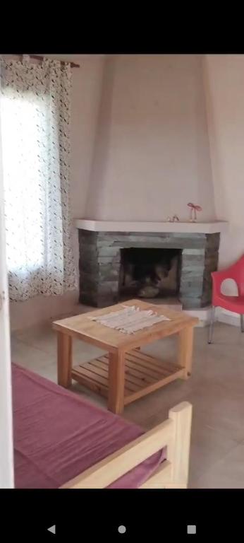 a living room with a fireplace and a red chair at Cabaña Dina in Santa Rosa del Conlara