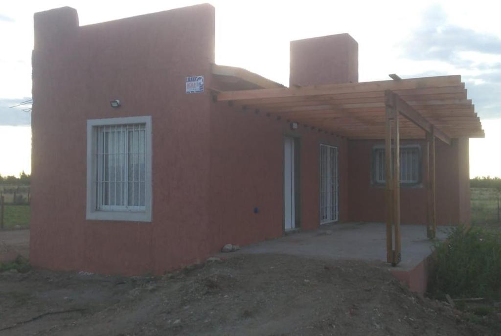 a small red house with a wooden roof at Cabaña Dina in Santa Rosa del Conlara