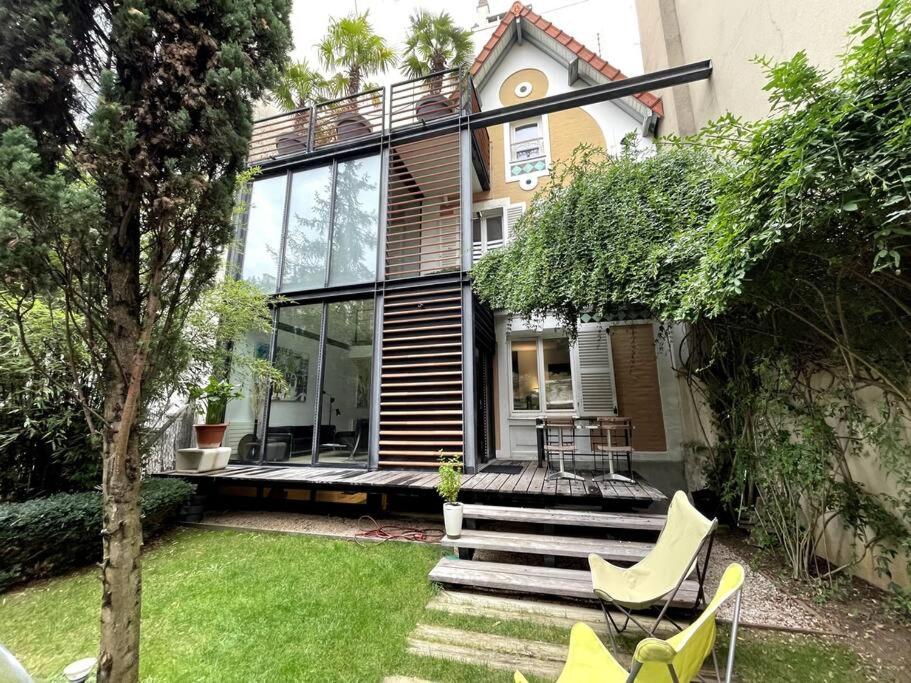 une maison avec des fenêtres en verre et des chaises dans une cour dans l'établissement Architect house - 20min Paris - SUMMER & Olympics 2024, à Courbevoie