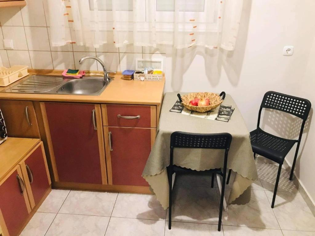 a small kitchen with a table and chairs and a sink at Apartment ARION 3 in Larisa
