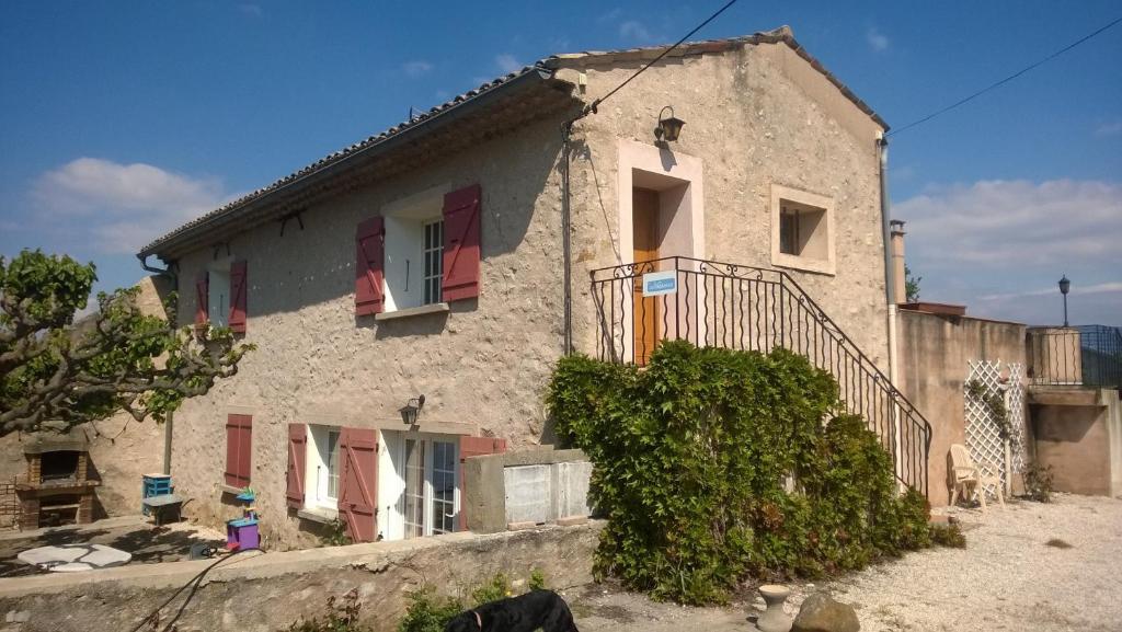 a house with red shuttered windows and a staircase at Gite Nyons in Mirabel-aux-Baronnies