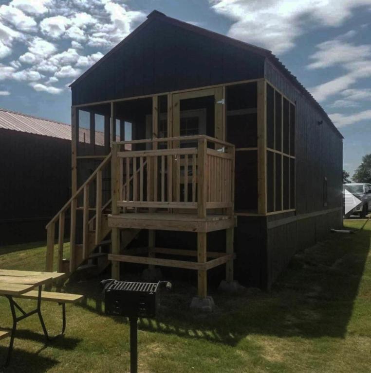 a tiny house with a porch and a picnic table at Lakefront Cedar Cabin - 10 in Mead