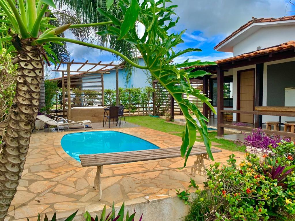 un patio trasero con una piscina, un banco y una casa en Casa de Temporada em Capitólio (Charme e Aconchego), en Capitólio