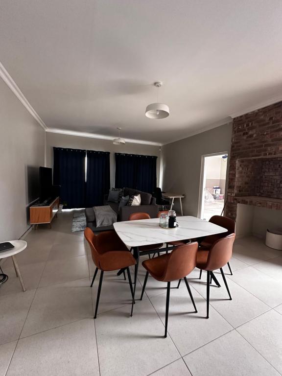 uma sala de estar com uma mesa e cadeiras e um sofá em Cozy Home Self-Catering em Walvis Bay