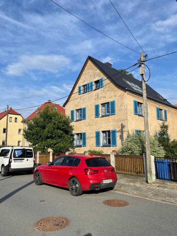 un coche rojo estacionado frente a una casa en Ferienwohnung Schneider, en Ottendorf-Okrilla