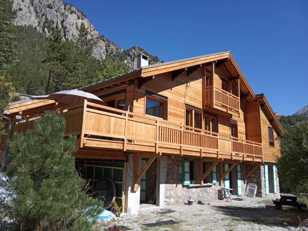 a large wooden house with a mountain in the background at Appartement RDC chalet 55m2 in Briançon