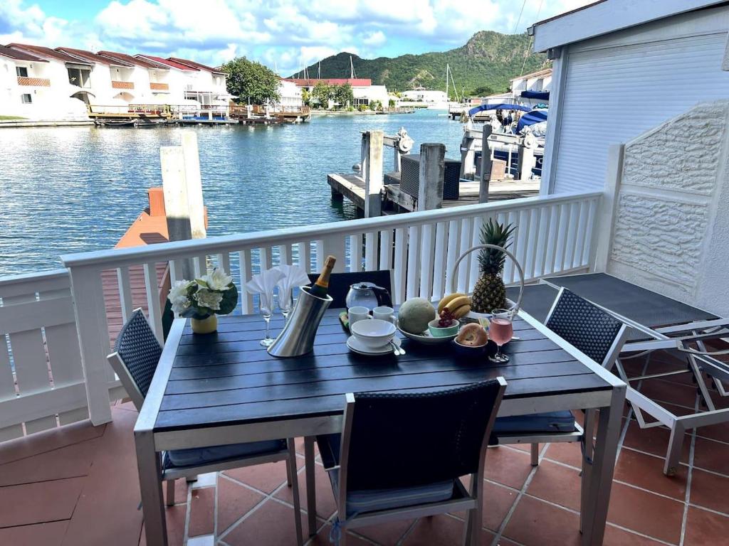 a table on a balcony with a view of the water at 4 Guests - Stunning View - Pool - South Finger in Jolly Harbour