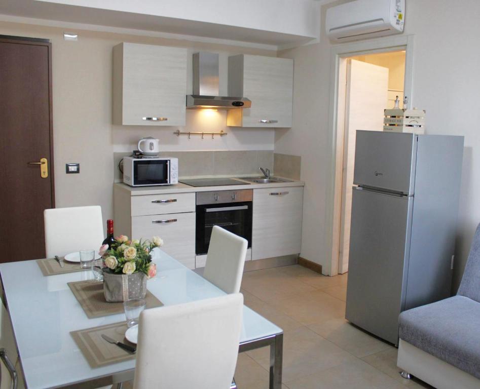 una cucina e una sala da pranzo con tavolo e frigorifero di Appartamenti la Piazzetta vicino a Firenze a Signa