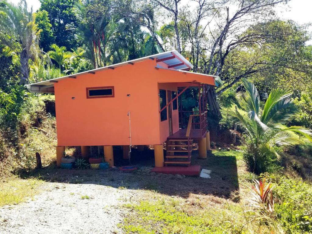 an orange house on a hill with trees at Tranquil Jungle Home-Casa Amado in Pavones