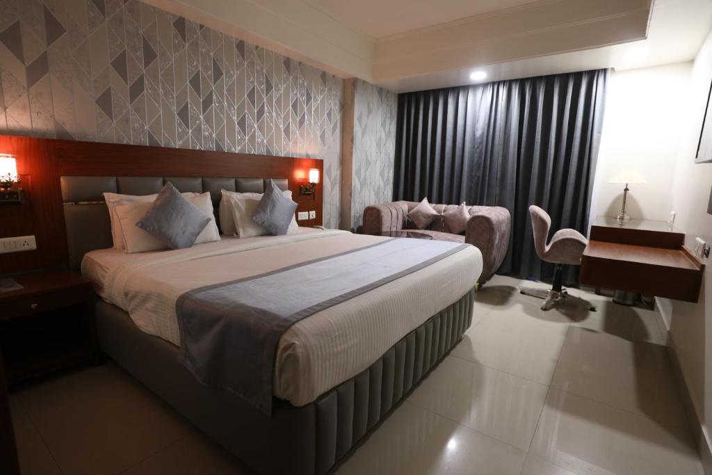 um quarto de hotel com uma cama grande e uma secretária em Eastin Hotels em Hyderabad