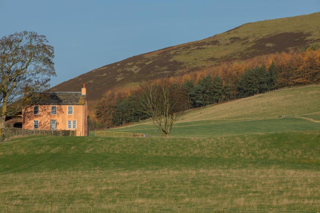 an old house on a hill in a field at Townhead in Peebles