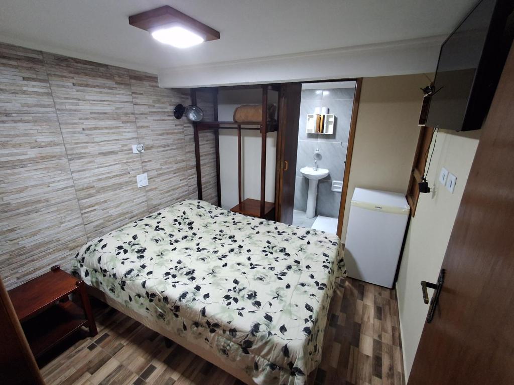 a small bedroom with a bed and a bathroom at Espaço Rural Água da Onça in Guararema