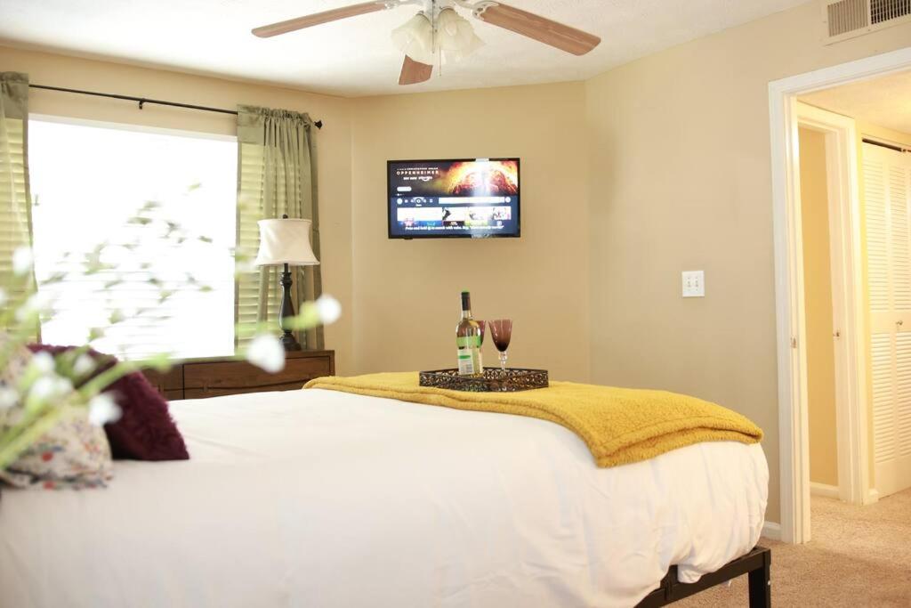 Entire 2 Bedroom Apt Home in Sandy Springs في ساندي سبرينغز: غرفة نوم مع سرير وتلفزيون على الحائط