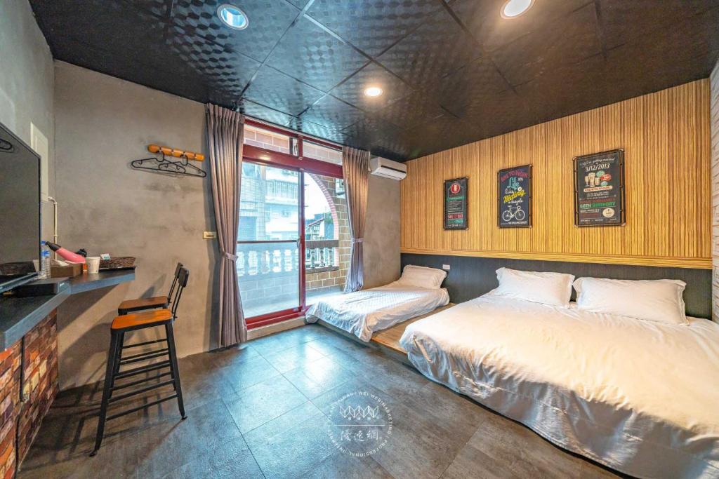 羅東鎮的住宿－羅東夜市 工業Loft旅宿 Night Market Loft House，一间卧室设有两张床、一张桌子和一个窗口。