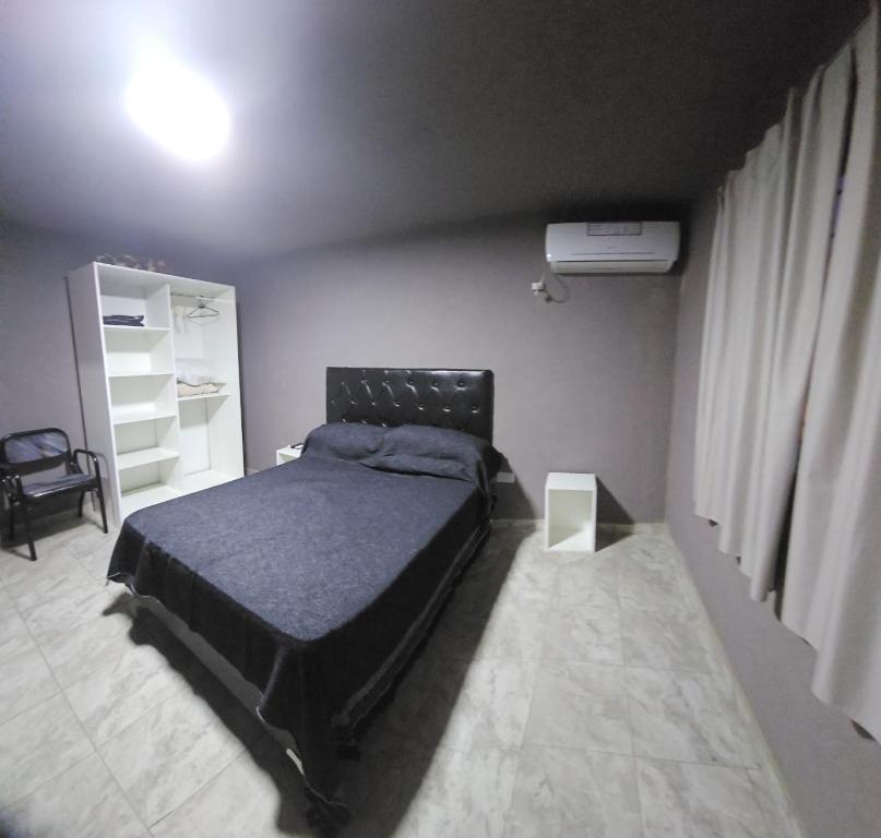 1 dormitorio con 1 cama negra en una habitación en La Blanqueada en Mina Clavero