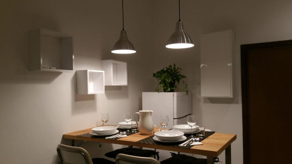 una mesa de comedor con copas de vino y luces en Fuori Portico Unità, en Bolonia