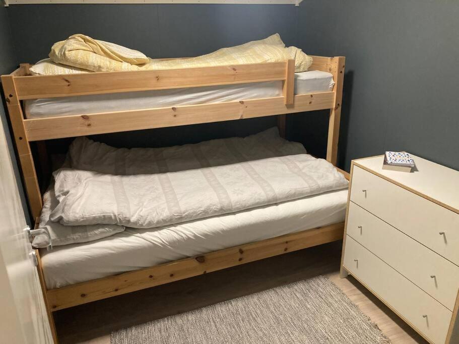 a wooden bunk bed in a room with a dresser at All new, fully equipped apartment at the gate of Senja 