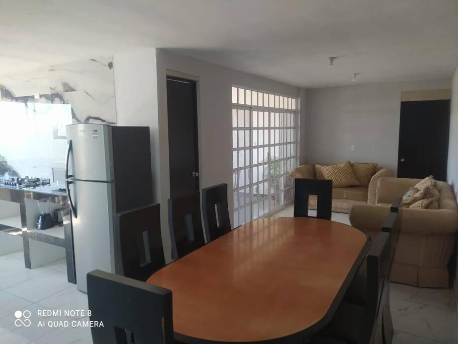 a kitchen and dining room with a table and a refrigerator at Casa para grupos hasta de 20 personas. Area ind 