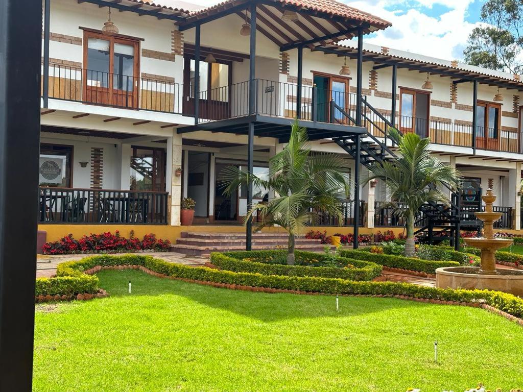 uma casa com um jardim em frente em Hotel Pliosaurio Campestre em Villa de Leyva