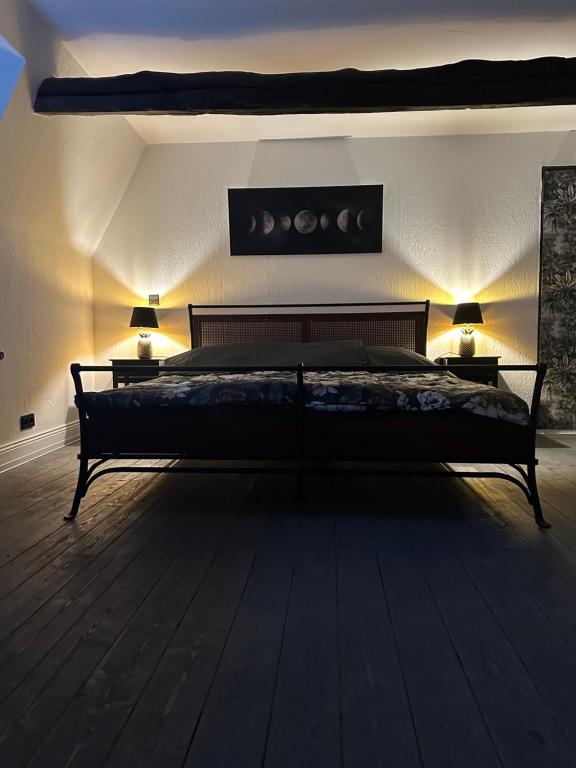 a bedroom with a large bed with two lamps on two tables at Urlaub im historischen Müllerhaus, Dachgiebel in Lübeck