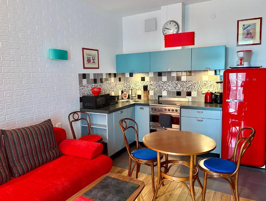 sala de estar con sofá rojo y cocina en Project Comfort Leszczyńska 4/33 Warszawa, en Varsovia