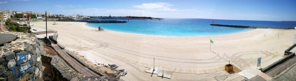 a large sandy beach with the ocean in the background at 1V - LUXURY APARTMENT NEAR BEACH in Puerto del Rosario