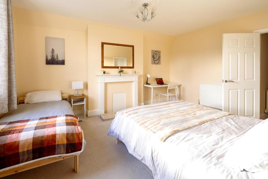a bedroom with two beds and a fireplace at Guildford Station with Parking in Stoughton