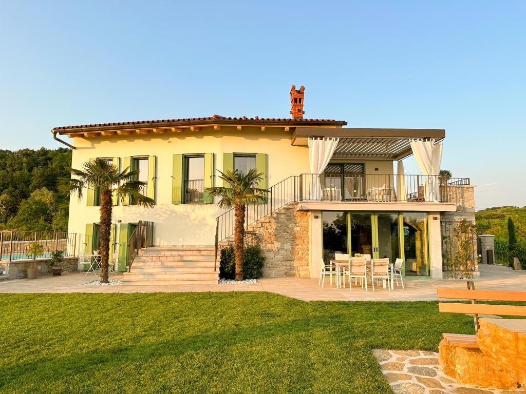 ドブロボにあるA Luxury 100m2 Apartment in a Chic Vineyard Villa - Ca' S. Lorenzのパティオと芝生のある大きな黄色の家