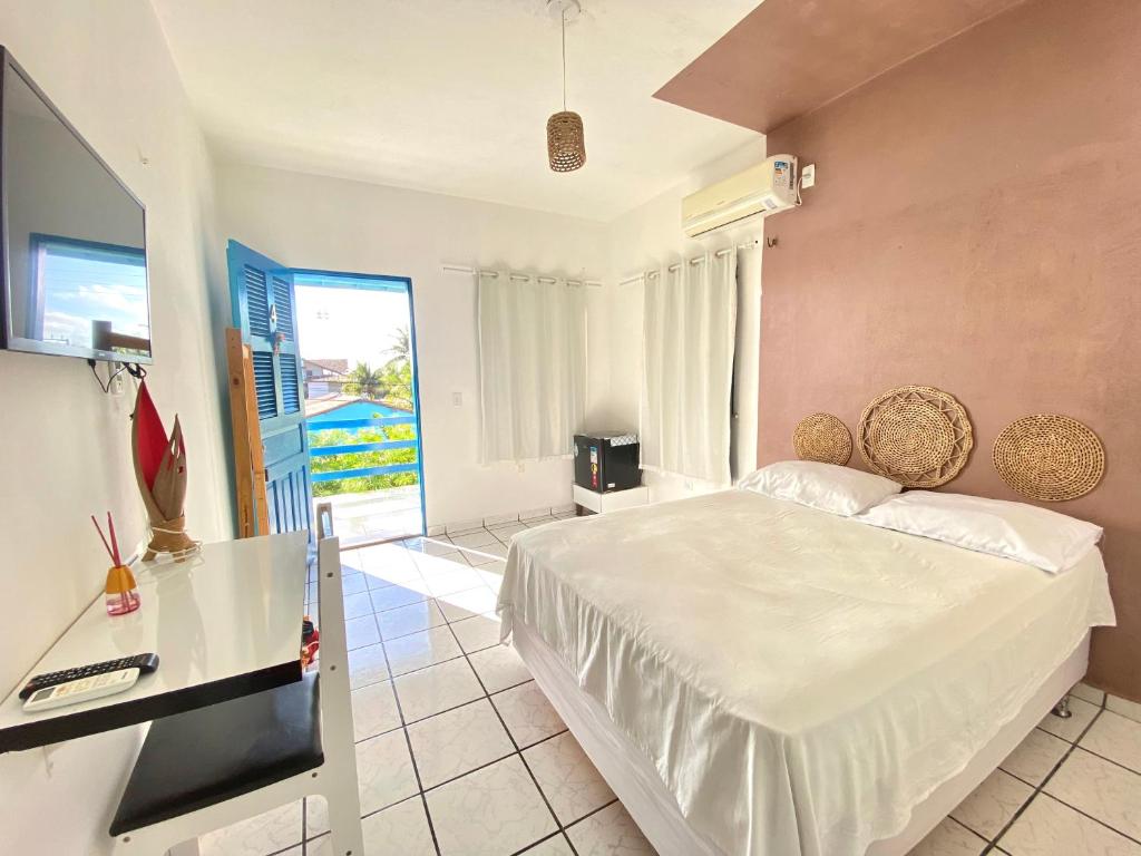 een slaapkamer met een bed, een bureau en een raam bij Pousada Capitolio 01 - Canoa Quebrada - hospedagem in Canoa Quebrada