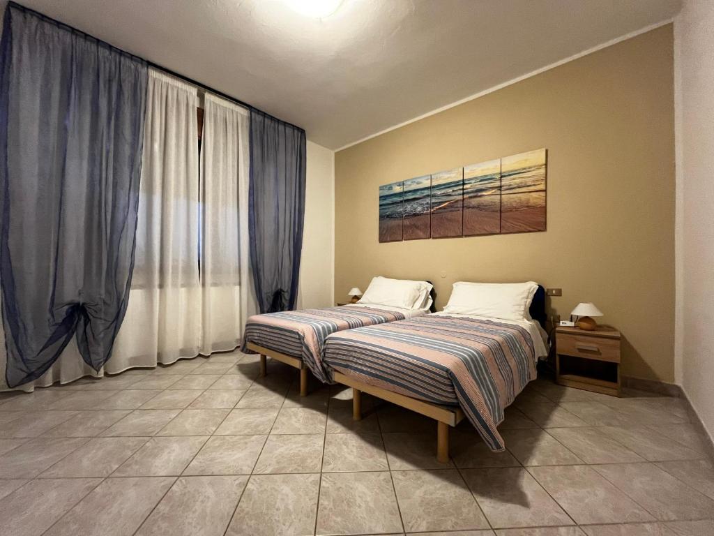 1 dormitorio con 2 camas y ventana en Casa Giulia, en Santa Giulia
