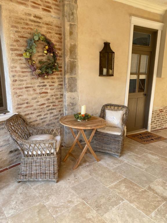 a patio with a table and two chairs and a candle at Les Hortensias in Canly