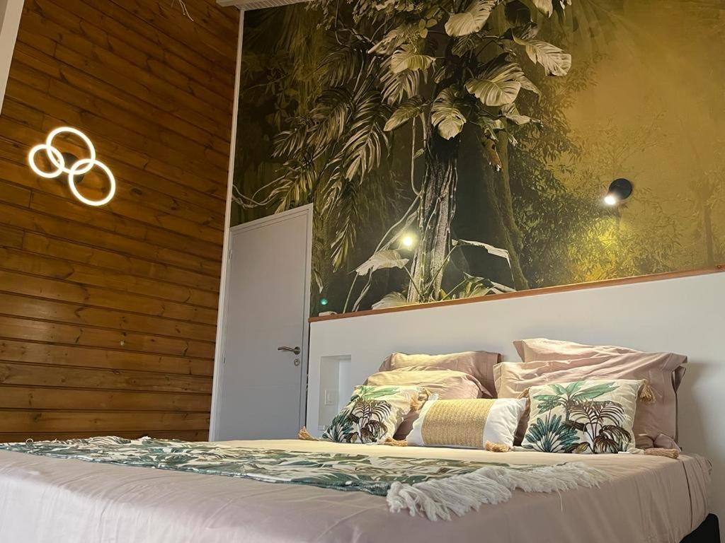 a bedroom with a bed with the olympics on the wall at Villa Cajou chambres d'hôtes chez l'habitant et Zanzibar cottage in Trois-Rivières