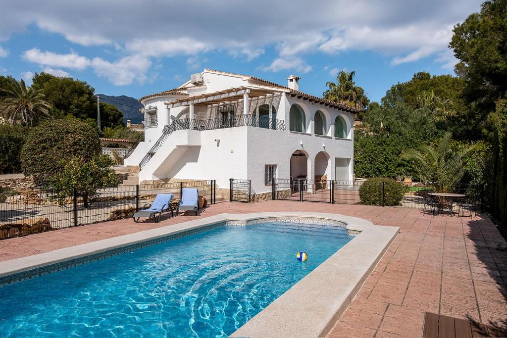 eine Villa mit einem Pool vor einem Haus in der Unterkunft Casa Molar in Altea